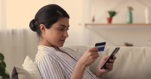 Relaxado sorrindo milenar mulher indiana compras em aplicativo móvel. — Vídeo de Stock