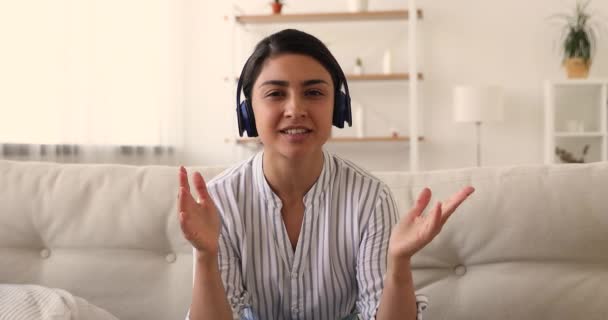 Mulher indiana bonita feliz em fones de ouvido falando olhando para a câmera. — Vídeo de Stock