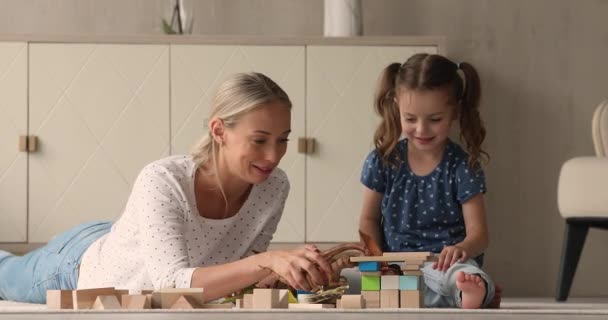 Moeder en dochtertje spelen dinosauriërs speelgoed en houten blokken — Stockvideo