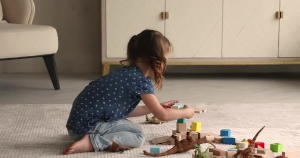 Pequeña niña construir con cubos de madera en la sala de estar — Vídeos de Stock