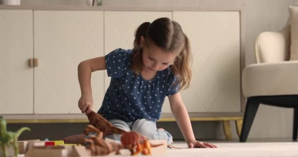 Niña jugar dinosaurio juguetes conjunto en casa — Vídeos de Stock