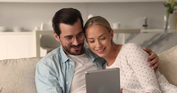 Casal bonito passar o tempo comprando na internet usando dispositivo tablet — Vídeo de Stock
