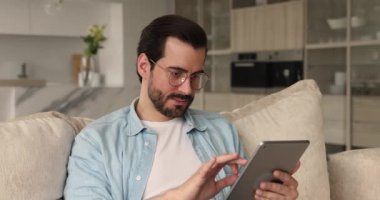 Tablet tutan mutlu adam sevinçle süper haber çığlığı okuyor.