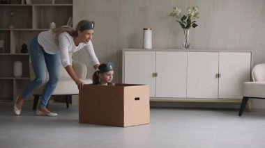 Karton kutunun içinde oturan çocuk annesiyle iyi yolculuklar.