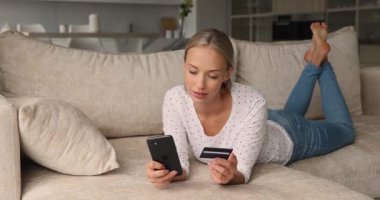 Kadının elinde internet üzerinden akıllı telefon kullanımı ile kredi kartı var.