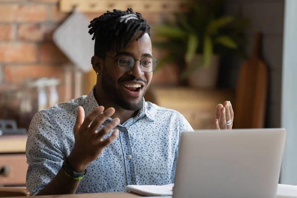 Alegre joven negro chapoteo manos mirando la pantalla del ordenador portátil — Foto de Stock