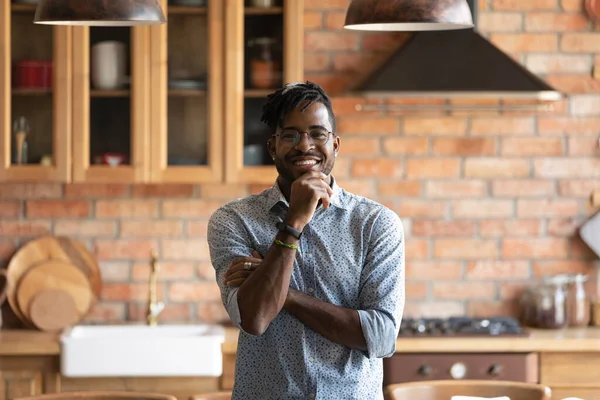 Leende afrikansk amerikansk man poserar för porträtt i köket interiör — Stockfoto