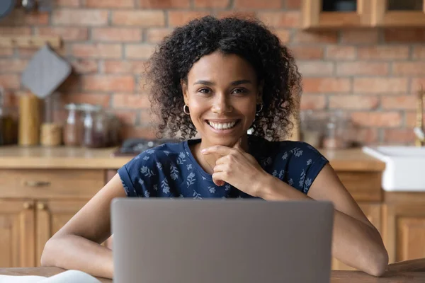 Glimlachende zelfverzekerde zwarte dame zitten door laptop op kantoor — Stockfoto