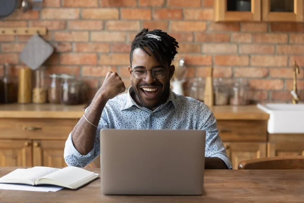 Spännande svart kille student ser bra tentamen resultat på laptop — Stockfoto