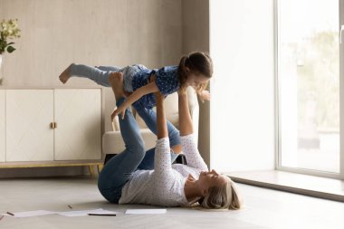 Mutlu anne ve küçük kız evde birlikte oynuyorlar.