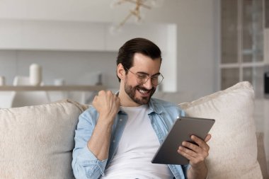 Mutlu adam tablet kullanıyor. İnternet piyangosunu kazan.