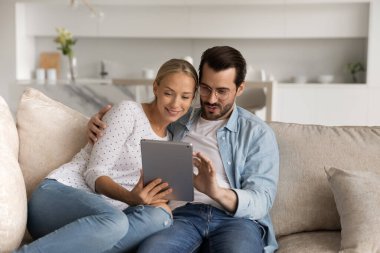 Mutlu çift evde tablet kullanarak rahatlıyor.