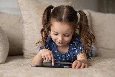 Küçük beyaz kız evde tablet kullanarak iyi eğlenceler.