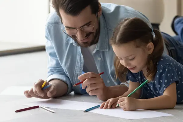 Feliz papá y su hijita dibujando en álbum — Foto de Stock