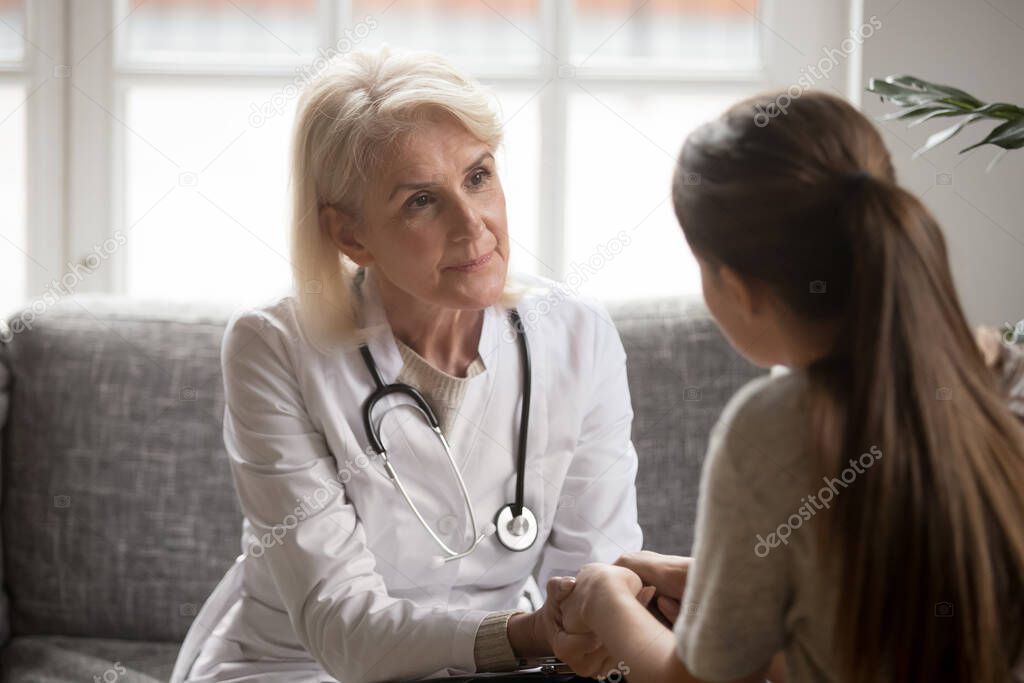 Senior female doctor show support to patient