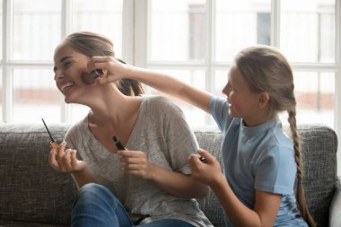 Mutlu küçük kız ve genç anne makyajda iyi eğlenceler.