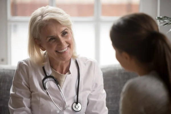 Smiling female doctor talk with patient in clinic