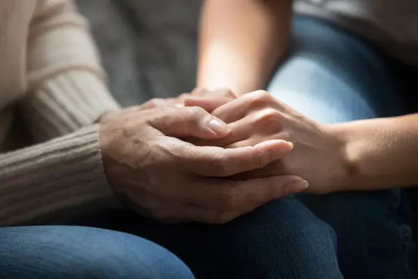 Close up of elderly mom and adult daughter hold hands — Stock Photo, Image