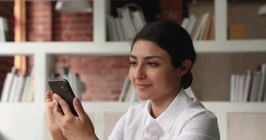Hintli iş kadını SMS okuyor. Mutlu gülüşmeler. İş başarısı.