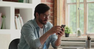 Akıllı telefon kullanan adam kötü haber okurken stresli hisseder.