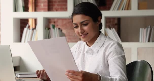 Indiase zakenvrouw controleren corporate papers voor te bereiden rapport met behulp van laptop — Stockvideo