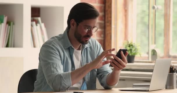 Homem segurando telefone inteligente leitura de boas notícias se sente feliz — Vídeo de Stock