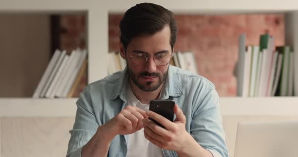 En mann med smarttelefon som leser utrolige nyheter, er henrykt – stockvideo