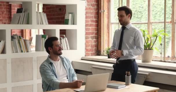 オフィスで休憩中にフレンドリーな会話をしている男性の同僚 — ストック動画