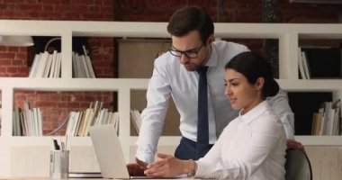 Bilgisayar yazılımını tartışan dizüstü bilgisayar kullanan çok ırklı meslektaşlar