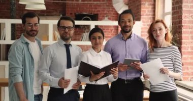 Çok ırklı iş adamlarından oluşan bir grup ofiste poz veriyor