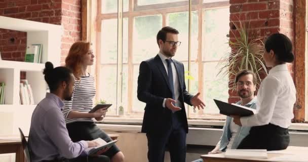 Skupina firemních zaměstnanců, kteří poslouchají šéfa během porady — Stock video