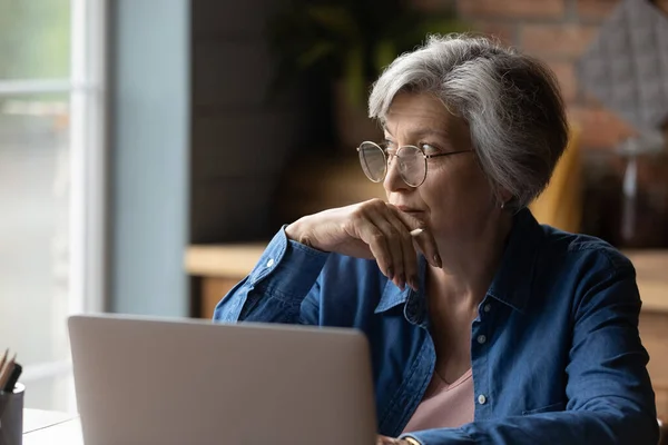 Pensive Lady důchodce studovat počítač přemýšlet o dalším kroku — Stock fotografie