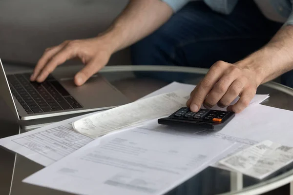 Fechar o homem usando calculadora e laptop, calculando contas domésticas — Fotografia de Stock