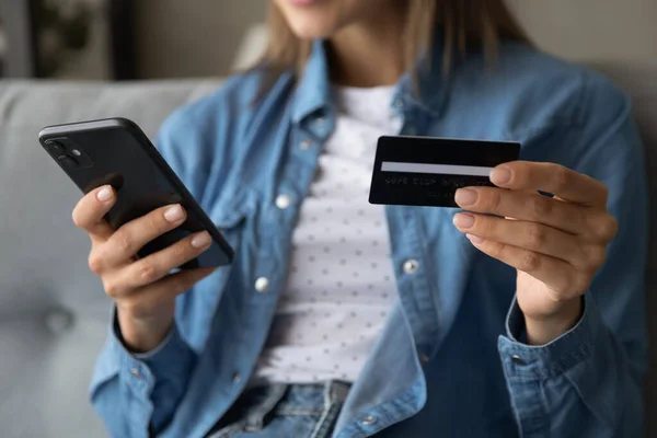 Close-up vrouw met plastic kaart en telefoon, internet betaling — Stockfoto