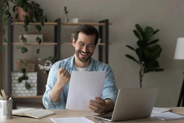 Happy man wearing glasses reading good news, showing yes gesture — Stock Photo, Image