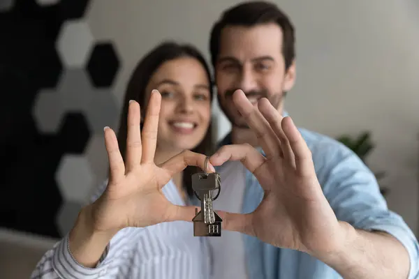 Primer plano feliz joven pareja mostrando llaves, primer apartamento propio —  Fotos de Stock