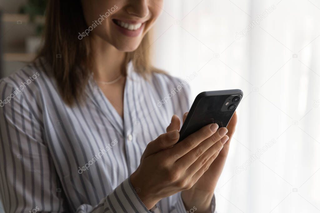 Close up smiling woman using smartphone, having fun with gadget
