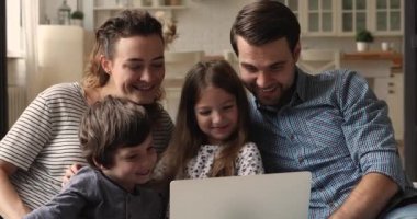 Küçük çocuklu bir çift kablosuz bilgisayardan aile filmi izliyor.