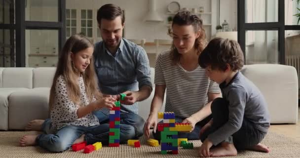 Jong stel en kinderen spelen kleurrijke blokken thuis — Stockvideo