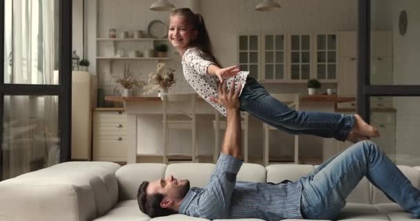 Güçlü bir baba, küçük kızının kollarını kaldırır. — Stok video