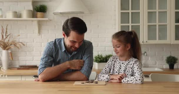 Amoroso jovem pai e pequena filha jogar damas em casa — Vídeo de Stock