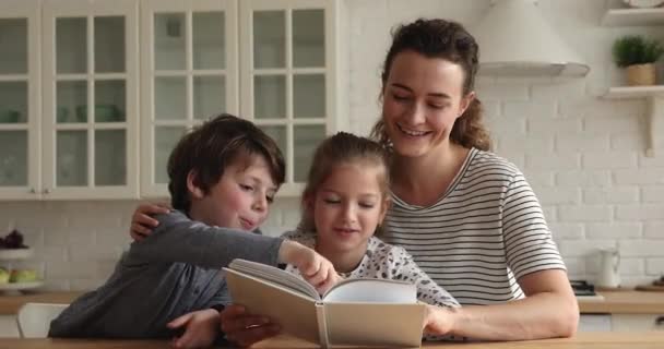 Loving mother reading a book to her little children — Stock Video