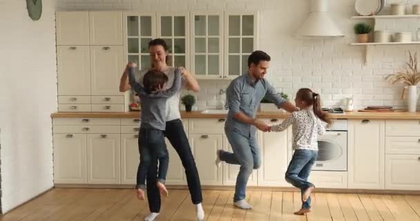 Pareja joven bailando con niños pequeños en casa — Vídeos de Stock