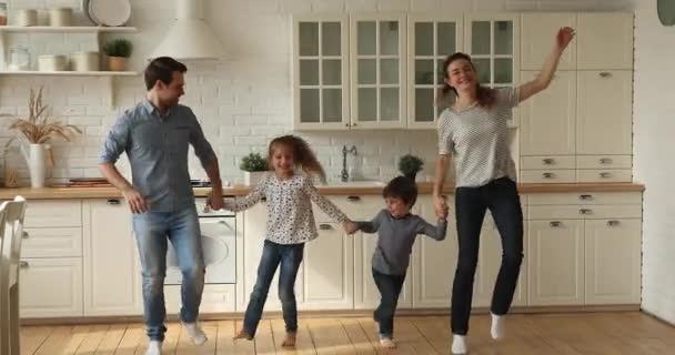 Ευτυχισμένο ζευγάρι που χορεύει με μικρά παιδιά στο σπίτι — Αρχείο Βίντεο