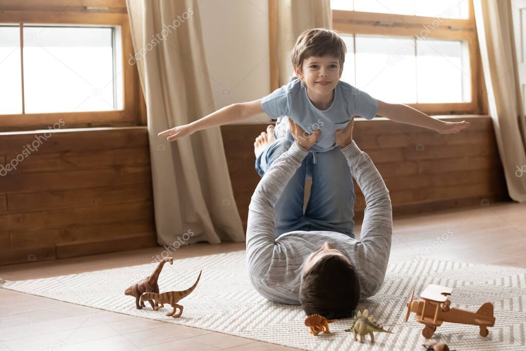 Happy father play at home with small son