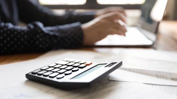 Закрыть женщину с помощью ноутбука, рассчитать счета, проверить финансовые документы — стоковое фото