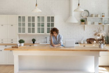 Genç beyaz kadın evden bilgisayarda çalışıyor.