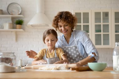 Mutlu Kafkasyalı anne ve küçük kızı birlikte yemek pişiriyor.