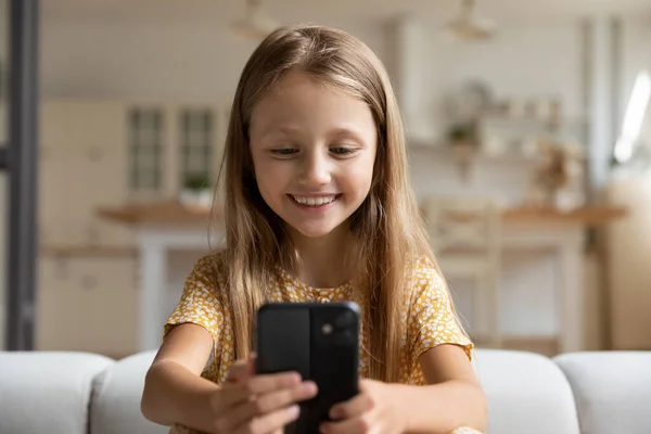 Smiling small girl talk on video call on cell — Stock Photo, Image