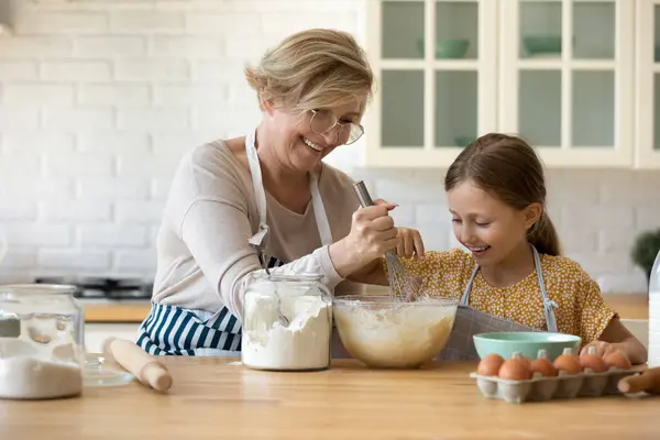 Happy grandmother and little granddaughter baking pies — Stock Photo, Image